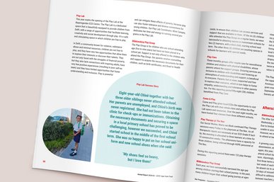 Der aufgeschlagene Jahresbericht zeigt ein Bildmotiv eines Mädchens und seine Geschichte