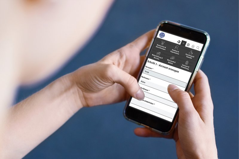 Eine Studierende hat die Anmeldeseite für das Studium auf einem Smartphone geöffnet