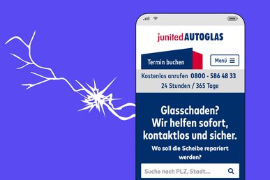 Die Startseite von junited Autoglas ist in einem Smartphone abgebildet