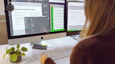 Beispiel für Erstellung von barrierefreien PDFs in InDesign Blick über die Schulter von Kathrin Scholz, die am Monitor barrierefreien InDesign-Dateien anlegt