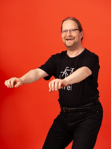 Olaf Schmidt-Wischhöfer macht lächelnd eine Kniebeuge