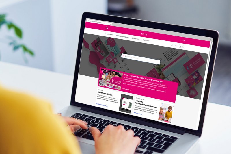 Auf dem Monitor einer Frau ist die Loginmaske der Telekom Brand und Design Plattform geöffnet