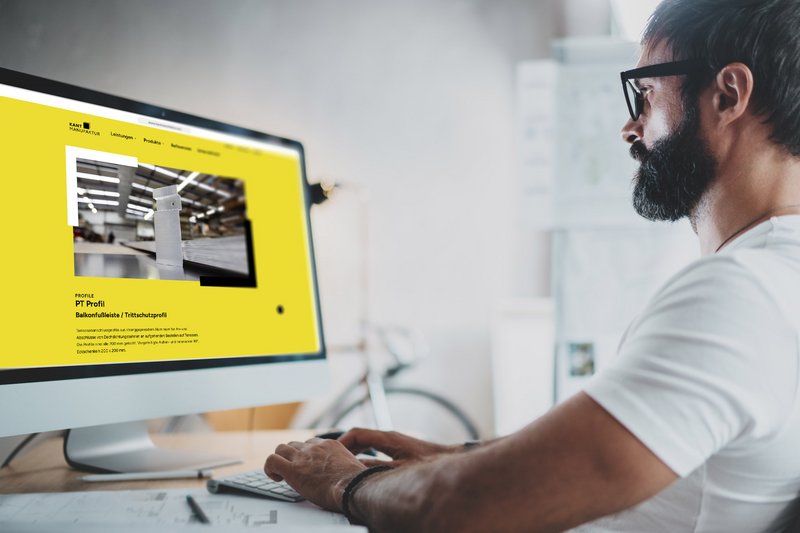 Ein Architekt sieht sich die Website der Kantmanufaktur auf einem Monitor an.