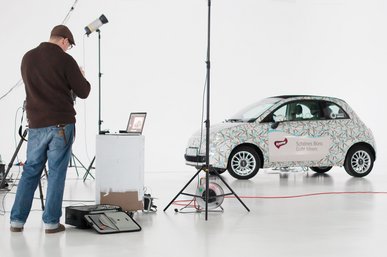 Bei einem Fotoshooting steht ein für umixx gebrandetes Auto im Zentrum
