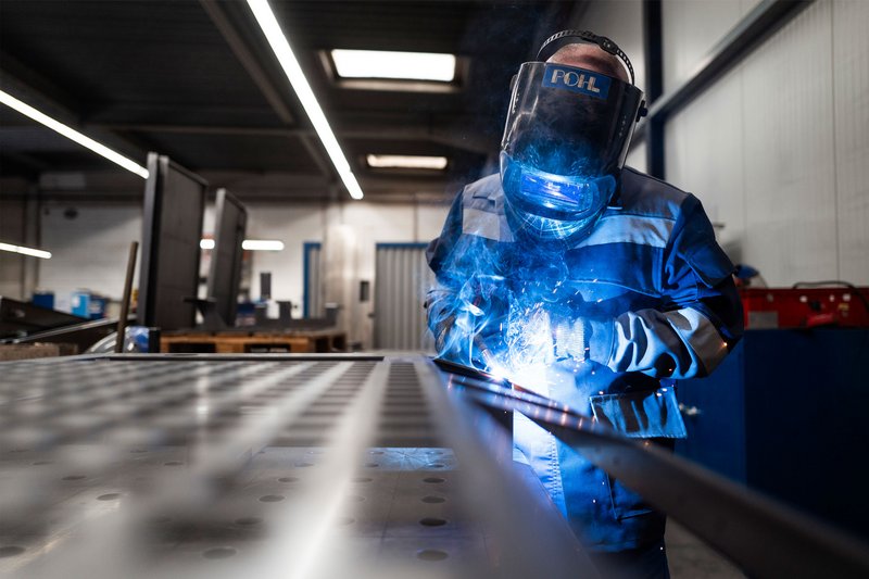 Ein Mitarbeiter von POHL in Arbeitsschutzkleidung bei der Metallbearbeitung