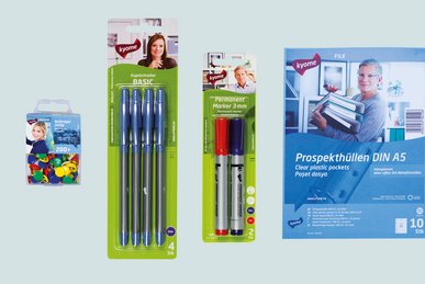 Die kyome Produkte darunter Kugelschreiber, Prespekthüllen und Reißnägel liegen nebeneinander.