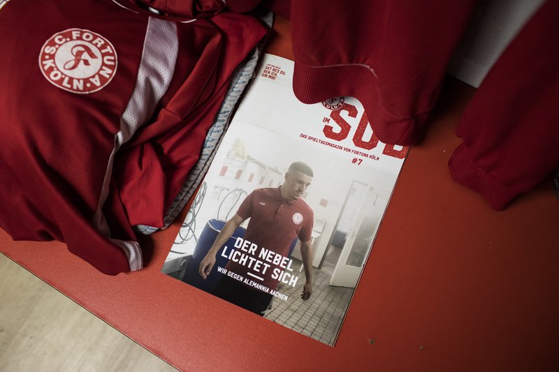 Das Magazin Heimspiel liegt im Umkleideraum auf einer Bank neben Fortuna Köln Trainingsjacken