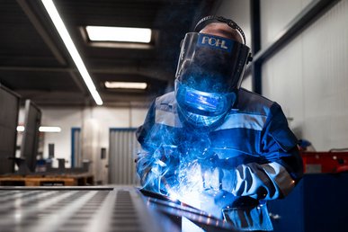 Ein Mitarbeiter von POHL in Arbeitsschutzkleidung bei der Metallbearbeitung